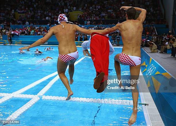 Players and a member of the coaching staff celebrate after winning gold during the Men's Water Polo Gold Medal match between Croatia and Italy on Day...