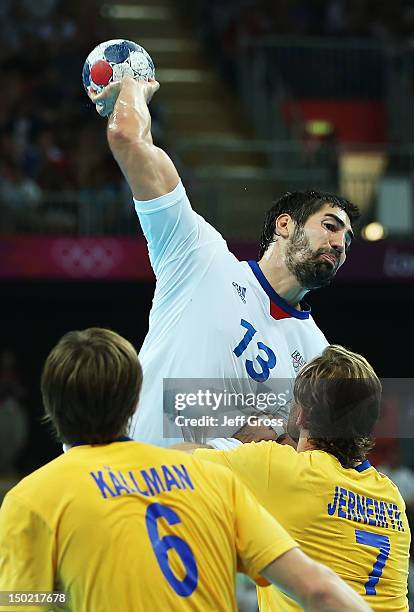 Nikola Karabatic of France shoots over Jonas Kallman and Magnus Jernemyr of Sweden during the Men's Handball Gold Medal Match on Day 16 of the London...