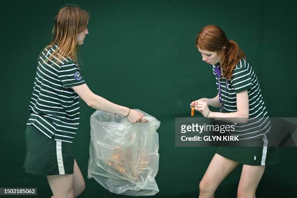 Ball girls pick up the orange confetti thrown by a Just Stop Oil demonstrator on court 18 on the third day of the 2023 Wimbledon Championships at The...