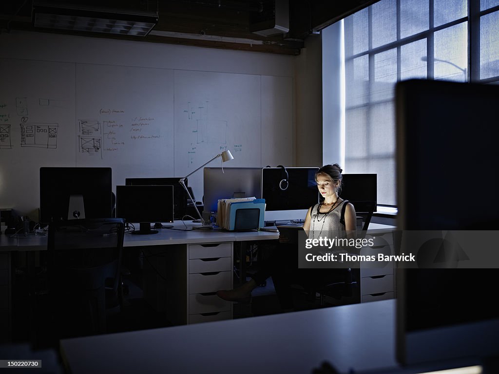 Businesswoman working on digital tablet at night