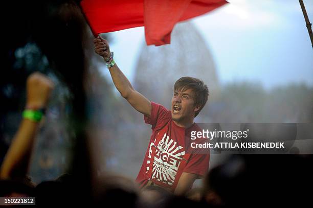 Fans of Russian 'Leningrad' band listenat the World-Music stage of the Sziget Festival on August 12, 2012 on 'Hajogyar' Island in Budapest during the...