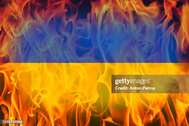 flag of ukraine on the background of the flame - russia military stock pictures, royalty-free photos & images