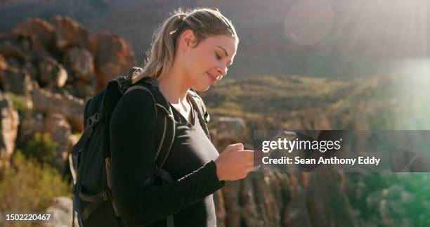 frau, wandern und orientierungssuche mit handy in den bergen, abenteuer oder fitness mit lächeln im sommer. glückliches wandermädchen, smartphone und sms in der social-media-app, reise oder training bei sonnenschein - snap stock-fotos und bilder