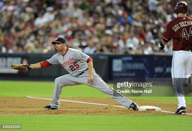 Adam LaRoche of the Washington Nationals cant come up with a throw in the dirt as Paul Goldschmidt of the Arizona Diamondbacks runs to first base at...