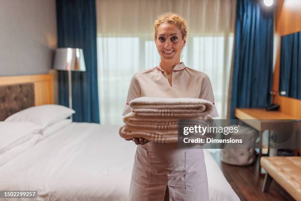 portrait of hotel maid holding clean towels - clean house stockfoto's en -beelden