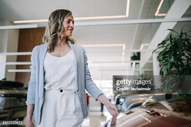 woman looking for a new car - sustainable energy candid stock pictures, royalty-free photos & images