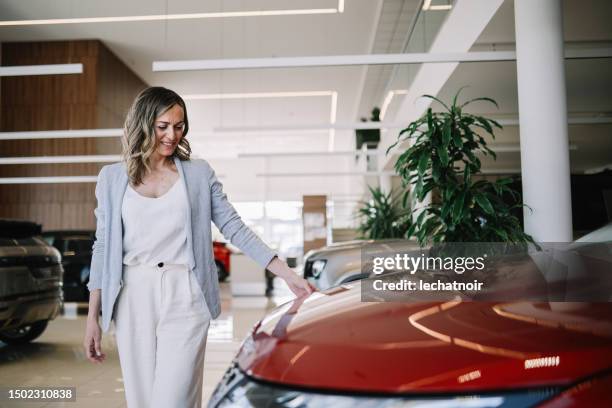 donna di mezza età fiduciosa che cerca la nuova auto - automobile di lusso foto e immagini stock