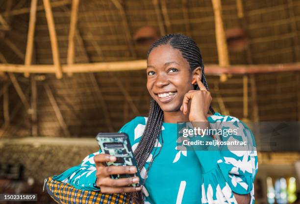 shot of a beautiful young african woman using headphones - east africa stock pictures, royalty-free photos & images