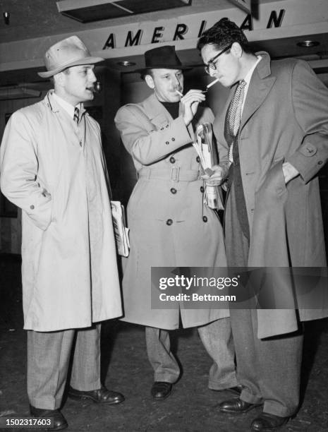 Film director Edward Dmytryk, screenwriters Alvah Bessie and Ring Lardner Jr prepare to board a flight to Washington where they are to appeal against...