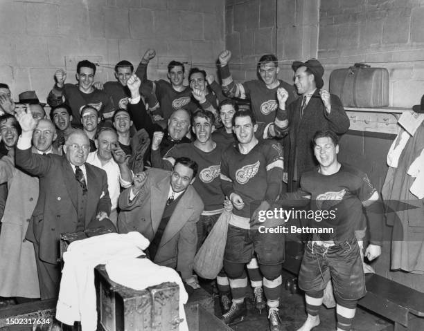 Members of the Detroit Red Wings celebrate in the Boston Garden arena's dressing room after beating the Boston Bruins in the final game of the...