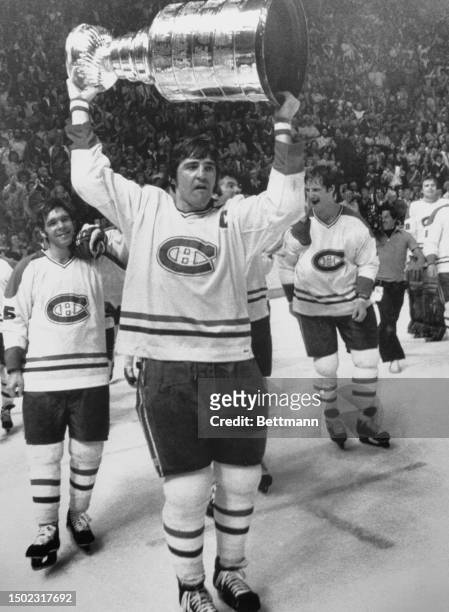 The Montreal Canadiens' captain Serge Savard leads raises the Stanley Cup trophy above his head after his team won the championship for the fourth...
