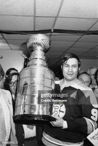 The Boston Bruins' John Bucyk poses with the Stanley Cup in the dressing room after the Bruins' win over the New York Rangers, Boston Garden arena,...