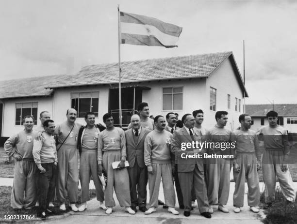 Members of the Argentine Olympic team stand in front of their country's flag at the Olympic village in Melbourne, Australia, November 18th 1956.