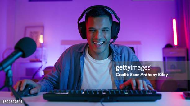 happy, jeu et portrait d’homme avec clavier pour esports, jeux vidéo et compétition virtuelle. joueur néon, informatique et masculin avec des écouteurs pour jouer au cyber, au rpg et aux jeux en ligne sur pc au bureau - joueur de jeux informatiques photos et images de collection
