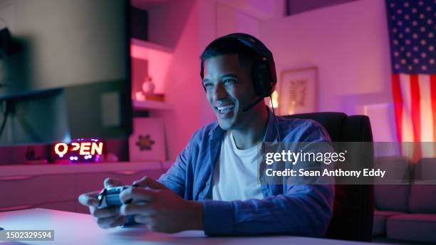 happy man, video game and headphones with live streaming and esports, computer and gamer playing in gaming room. technology, competition and winning with male person, cyber world and controller - control room monitors stockfoto's en -beelden