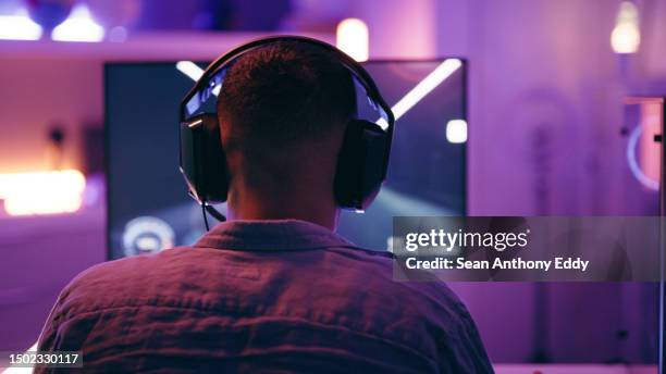 neon, jeux et dos de l’homme avec pc pour la diffusion en direct d’esports, de jeux vidéo et de compétitions virtuelles. bureau, ordinateur et joueur masculin avec des écouteurs pour jouer cyber, rpg et jeu en ligne à l’écran - dos humain photos et images de collection