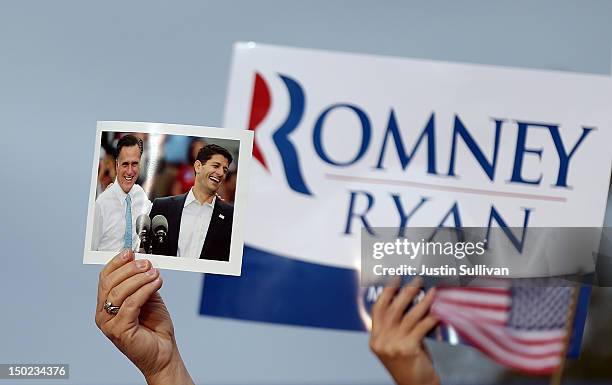 Supporter holds a photo Republican presidential candidate and former Massachusetts Governor Mitt Romney and his running mate Rep. Paul Ryan during a...