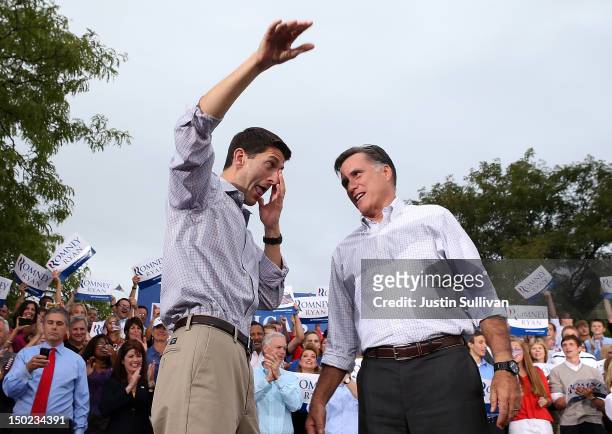 Republican presidential candidate and former Massachusetts Governor Mitt Romney looks on as his running mate Rep. Paul Ryan wipes away tears during a...