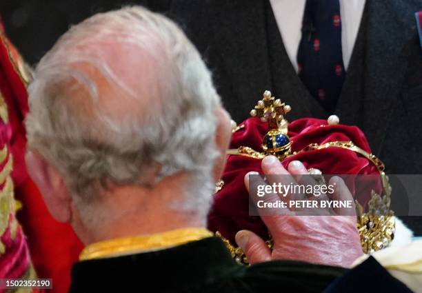 Britain's King Charles III is presented with the Crown of Scotland, part of the Honours of Scotland, during a National Service of Thanksgiving and...