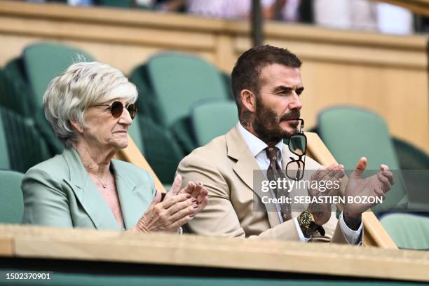 Former British football player David Beckham and his mother Sandra Beckham applaud as they sit in the royal box in Center Court during the women's...