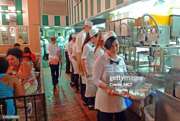 Waiters serve patrons at Cafe du Monde in New Orleans, Louisiana.