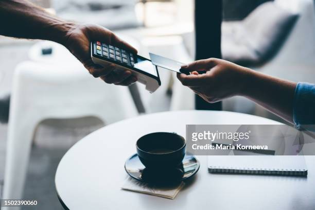woman pays with a card in a cafe. - credit card terminal stock pictures, royalty-free photos & images