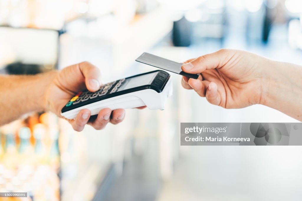 Woman pays with a card in a cafe.