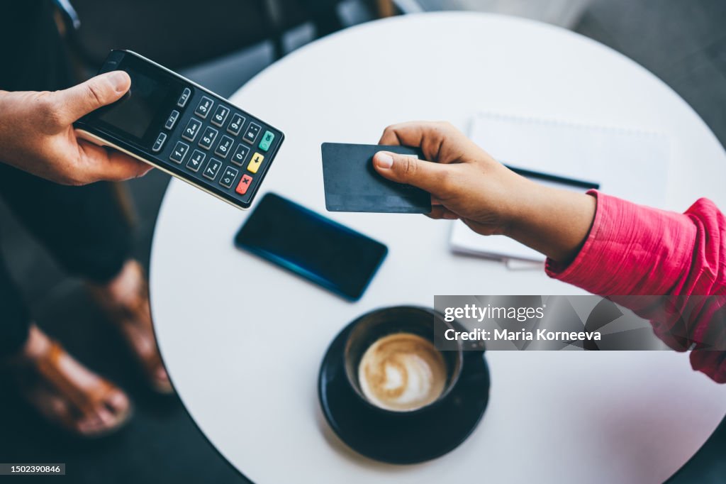 Woman pays with a card in a cafe.