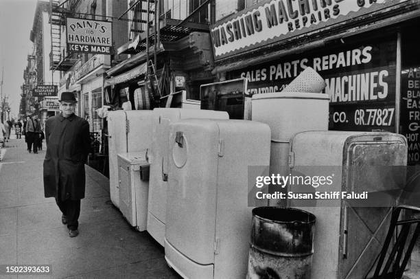 Man walks outside a second hand appliance shop in Manhattan's First Avenue, New York City, circa 1970.