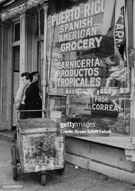 Spanish American supermarket window in Manhattan's First Avenue with signs in English and Spanish, New York City, circa 1970.