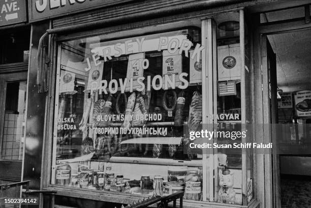 The exterior of a butcher's shop in First Avenue, Manhattan, showing various meats and pickles in its window with signs in English, Polish, Slovak,...