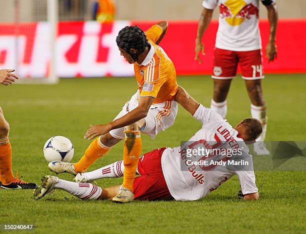 Calen Carr of the Houston Dynamo and Joel Lindpere of the New York Red Bulls battle for a loose ball during the game at Red Bull Arena on August 10,...