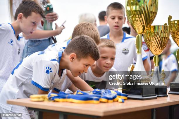 Football players look at the trophies and medals for the winners during the "Irpin Cup" tournament on June 24, 2023 in Irpin, Ukraine. The children’s...