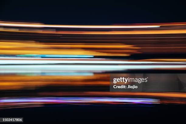 blurred motion photographic effect of city lights at night - lichtspur stock-fotos und bilder