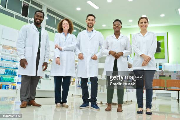 team of pharmacists in pharmacy - pharmacist stock pictures, royalty-free photos & images