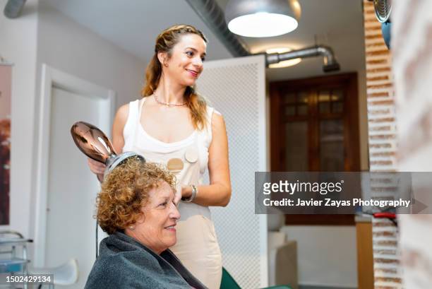 senior woman getting new hair cut at beauty salon - blow drying hair stock pictures, royalty-free photos & images