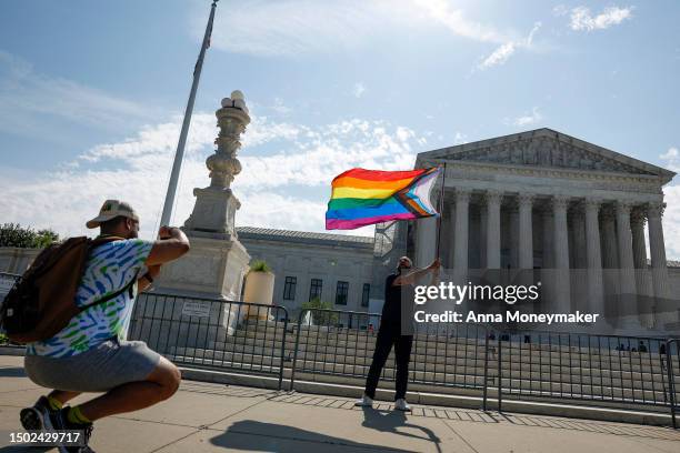 Same-sex marriage supporter Vin Testa, of Washington, DC, waves an LGBTQIA+ pride flag in front of the U.S. Supreme Court Building as he makes...