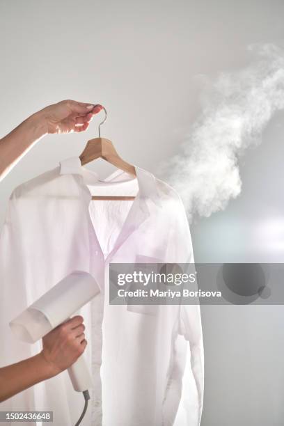 woman's hand with a steamer. lots of steam. - iron appliance stockfoto's en -beelden