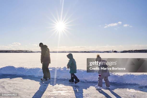 a family of dad and two children of different sexes go skating. - figure skating child stock pictures, royalty-free photos & images