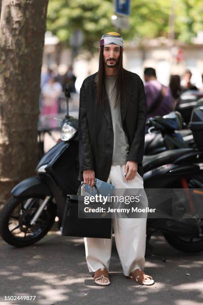 Julian Daynov is seen wearing a colorful bandana, black blazer, grey shirt, creme beige wide leg pants, black leather Hermes Kelly bag and brown...