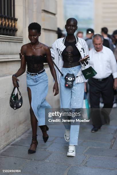 Fashion Show Guest is seen wearing strapless black transparent top with sewn-in black roses and a denim rock which is short on one side and long on...