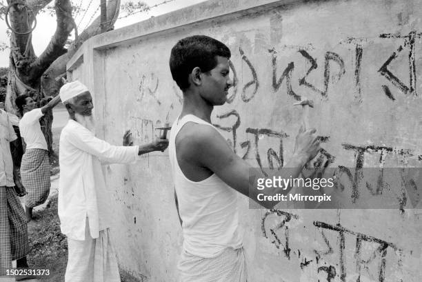 Bangladesh - signs being chipped off walls, by order of the Military Government.