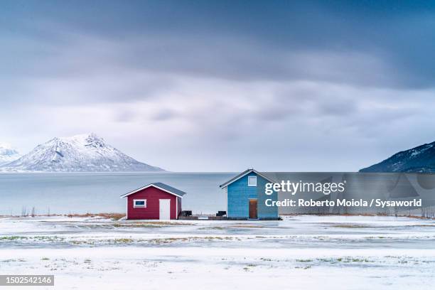 fishermen cabins on a frozen beach covered with snow - island hut stock pictures, royalty-free photos & images