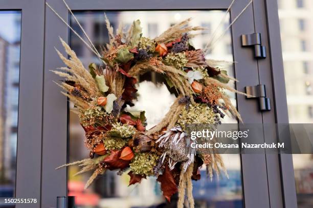 beautiful autumn wreath hanging on door - autumn wreath stock pictures, royalty-free photos & images