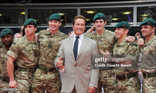 Actor Arnold Schwarzenegger poses with members of the military at the UK Film Premiere of 'The Expendables 2' at Empire Leicester Square on August...