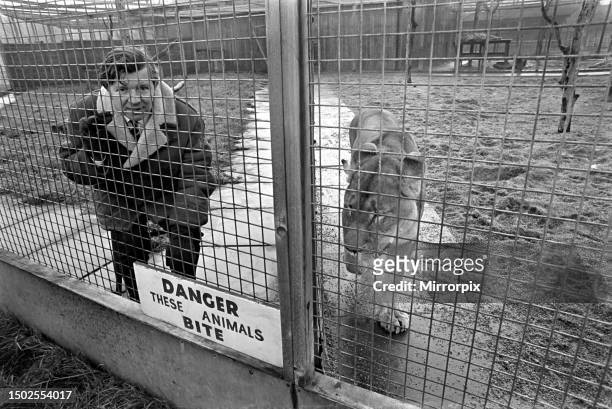 Man in a lion cage at Birmingham Zoo for a political demonstration. December 1969.