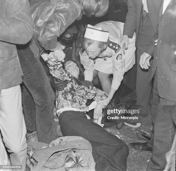 Rolling Stones. A fan lays on the ground being tended to by a St Johns Ambulance Brigade nurse after collapsing during the band's gig at the Lyceum,...