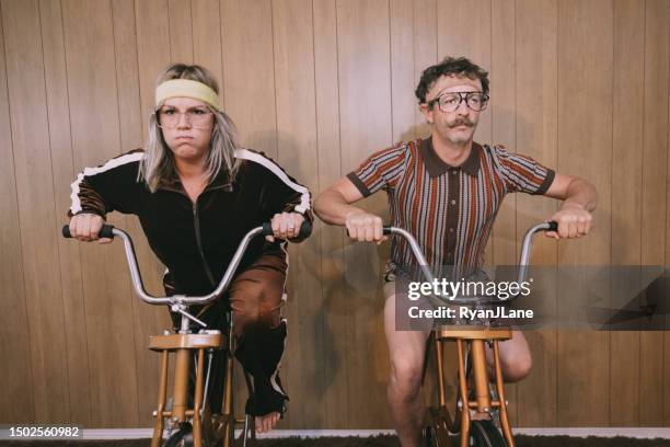 retro nineteen eighties aesthetic exercise bike couple - sweet bizarre vintage rides imagens e fotografias de stock