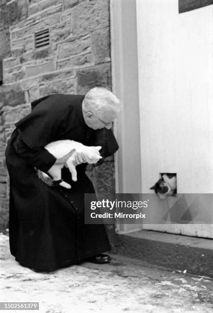 The parish priest seen here gathering up his pet cats. 13th February 1970 .