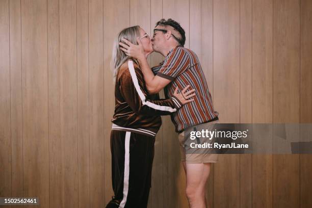 retro nineteen eighties aesthetic exercise couple kiss between workouts - funky middle age couple stockfoto's en -beelden